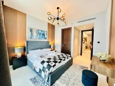 a bedroom with a bed and a chandelier at Burj Khalifa View Modern 2BR CVG in Dubai