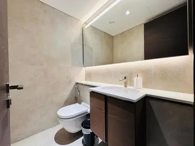 a bathroom with a toilet and a sink and a mirror at Burj Khalifa View Modern 2BR CVG in Dubai