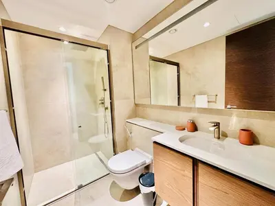 a bathroom with a toilet and a sink and a shower at Burj Khalifa View Modern 2BR CVG in Dubai