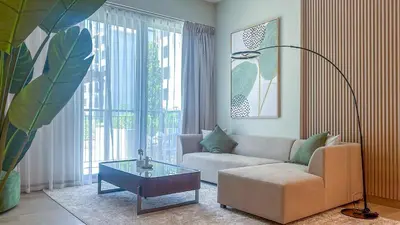 a living room with a couch and a glass table at Peaceful 1BR in La Serine, Lush Garden Views - 1AB02 in Dubai
