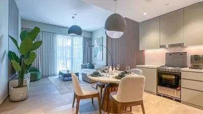 a kitchen and dining room with a table and chairs at Peaceful 1BR in La Serine, Lush Garden Views - 1AB02 in Dubai