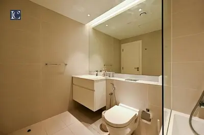 a bathroom with a toilet and a sink and a mirror at Luxury Escapes - Stylish 2-Bedroom Haven in La Cote, Port de La Mer in Dubai