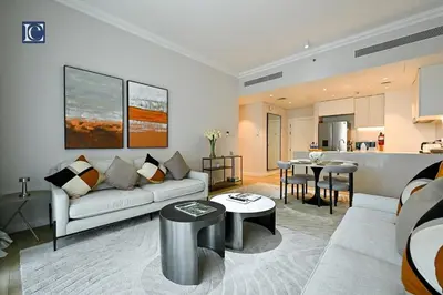 a living room with a couch and a kitchen at Luxury Escapes - Stylish 2-Bedroom Haven in La Cote, Port de La Mer in Dubai
