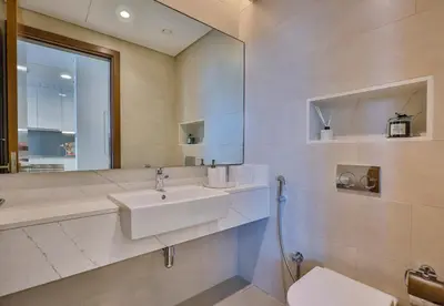 a bathroom with a sink and a mirror and a toilet at Burj Khalifa View - 2BR with Maids room in Canal Front 1, Al Wasl - Allsopp & Allsopp in Dubai