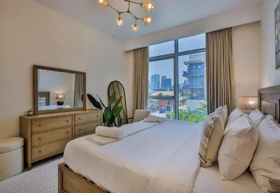 a bedroom with a large bed with a large window at Burj Khalifa View - 2BR with Maids room in Canal Front 1, Al Wasl - Allsopp & Allsopp in Dubai