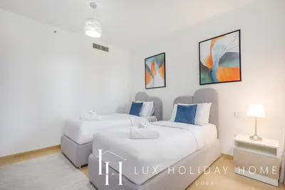 two beds in a white room with paintings on the wall at LUX The Murjan Sea View Suite 2 in Dubai