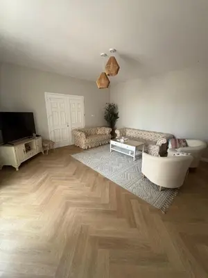 a living room with a couch and a tv at Barsha South Cozy Guesthouse in Dubai