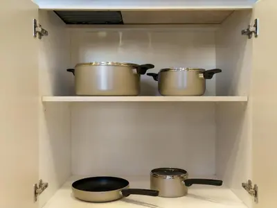 two pots and pans on a stove in a kitchen at The Town Square Suite Luxury 2BR Near Qudra Lake in Dubai