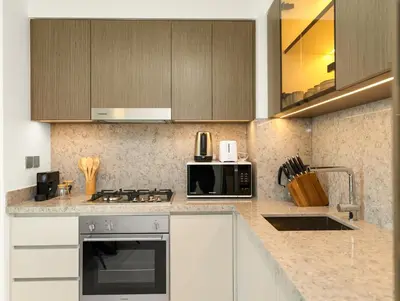 a kitchen with a stove and a microwave at Utra Lux Large 1 BR with Sunset Views and Private Beach in Dubai