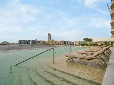 a group of lounge chairs sitting in the water on a building at Utra Lux Large 1 BR with Sunset Views and Private Beach in Dubai