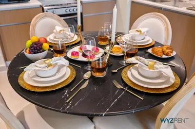 a black table with plates of food on it at Pink Panther Soft Glam 1BR in Surf 2-Creek Beach in Dubai