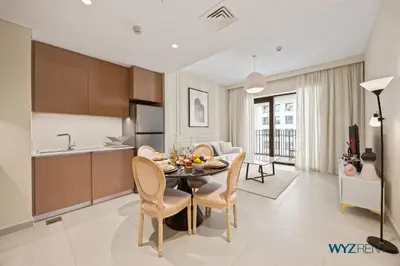 a kitchen and dining room with a table and chairs at Pink Panther Soft Glam 1BR in Surf 2-Creek Beach in Dubai