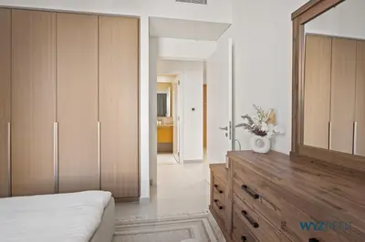a bedroom with a wooden dresser and a mirror at Earthy Elegant 1BR, Surf 2 Creek Beach Access in Dubai