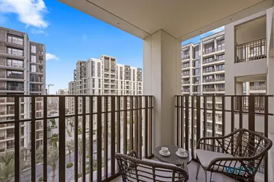 a balcony with two chairs and a table at Earthy Elegant 1BR, Surf 2 Creek Beach Access in Dubai