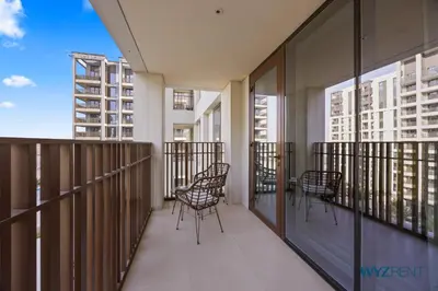 a balcony with chairs and tables on a building at Earthy Elegant 1BR, Surf 2 Creek Beach Access in Dubai