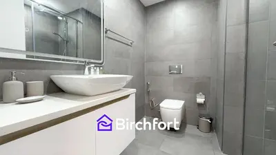 a bathroom with a sink and a toilet and a mirror at Stylish Stay Steps from the Marina in Dubai