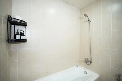 a bathroom with a tub and a shower with three people on a shelf at Great Flat Near Marina & Beach With Amazing View, Many Activities in Dubai