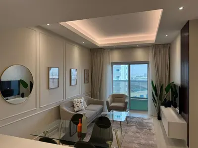 a living room with a couch and a mirror at Elegant One Bedroom in Sports City in Dubai