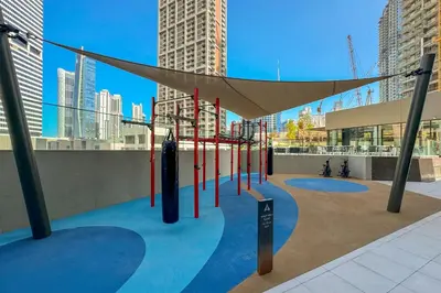 a playground in a city with tall buildings at Sleek 1Bedroom with Burj Khalifa view in Peninsula in Dubai