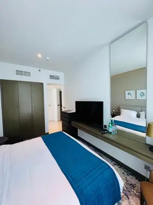 a bedroom with a large bed and a television at Maison Prive By DAMAC Studio in Dubai