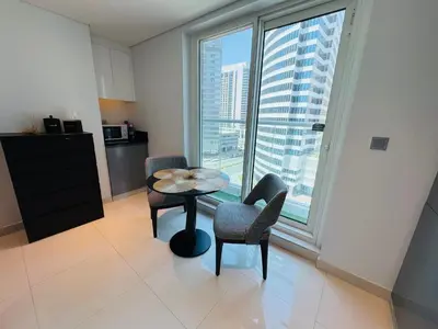 a room with a table and chairs and a large window at Maison Prive By DAMAC Studio in Dubai