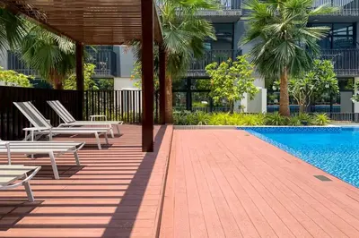 a resort with a pool and chairs and a building at Amazing 1BR with Pool in JVC in Dubai