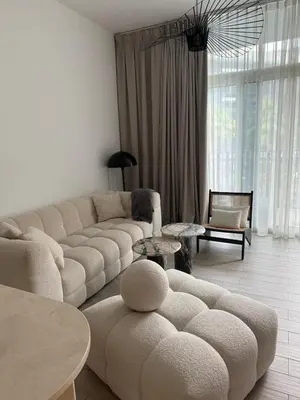 a living room with a couch and a table at Amazing 1BR with Pool in JVC in Dubai
