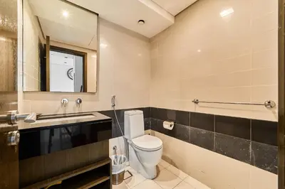 a bathroom with a toilet and a sink and a mirror at 2BR at Lofts West Near Dubai Mall and Burj Khalifa in Dubai