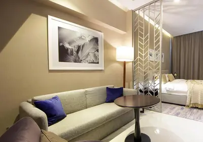 a living room with a couch and a bed at Modern Living DAMAC with Balcony & Waterfront Views in Dubai