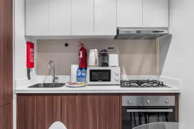 a kitchen with a sink and a microwave at Cozy 1 BR in the Center - 5 mins to Burj Khalifa in Dubai