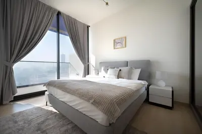 a bedroom with a large bed with a large window at Brand New Luxurious - Modern 1BR - Pool - Gym in Dubai