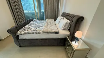 a bed in a room with a large window at 2BHK Garden Apartment at the heart of Dubai Marina in Dubai