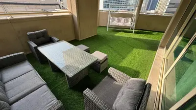 a room with a table and chairs on a balcony at 2BHK Garden Apartment at the heart of Dubai Marina in Dubai