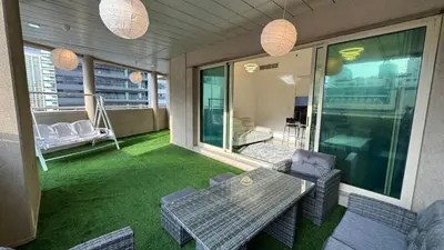 a screened porch with a table and chairs on a balcony at 2BHK Garden Apartment at the heart of Dubai Marina in Dubai