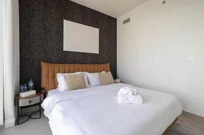 a bedroom with a large bed with a white blanket at Stunning Downtown 4BR Sky High Luxury Apartment with Fountain Views in Dubai