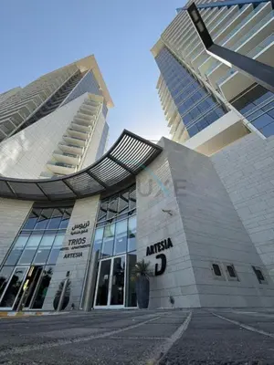 a large building with a palm tree in front of it at High-Rise Studio Near the Golf Club and Mall with a Community View,Damac Hills Artesia Tower D, Dubailand by Deluxe Holiday Homes in Dubai