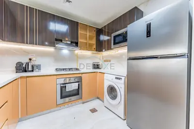 a kitchen with a refrigerator and a washer and dryer at City Views 2BR and Assistant Room with Mini Private Pool in Balcony, Gemz by Danube, Al Furjan by Deluxe Holiday Homes in Dubai
