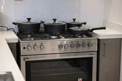 three pots sitting on top of a stove in a kitchen at Stay in Modern Elegance 4BR with Pool Gym and Boulevard Views in Dubai