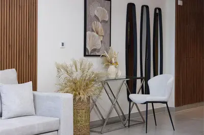 a living room with a glass table and chairs at Stay in Modern Elegance 4BR with Pool Gym and Boulevard Views in Dubai