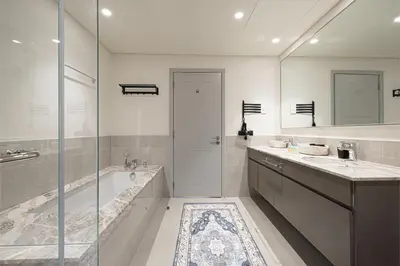 a bathroom with a tub and a sink and a shower at Stay in Modern Elegance 4BR with Pool Gym and Boulevard Views in Dubai