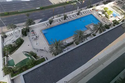 an overhead view of a large swimming pool with palm trees at Stay in Modern Elegance 4BR with Pool Gym and Boulevard Views in Dubai