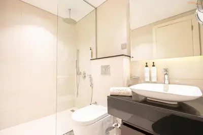 a white bathroom with a sink and a toilet at Bnbeyond's Artsy Canal-View Studio in the Heart of BBay in Dubai
