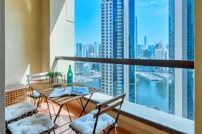 a balcony with a table and chairs and a view of a city at The Smart Concierge - Rimal 4 in Dubai