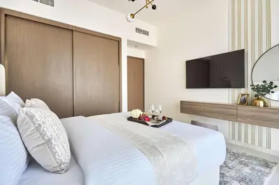 a bedroom with a white bed and a flat screen tv at Frank Porter - Grand Bleu Tower 2 in Dubai