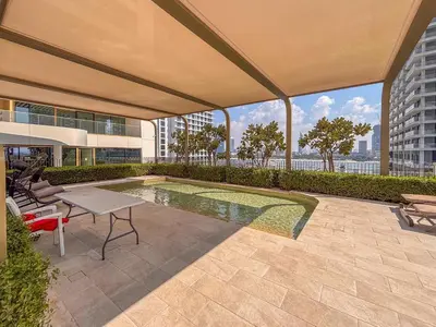 a patio with a table and chairs and a pool at Frank Porter - Grand Bleu Tower 2 in Dubai
