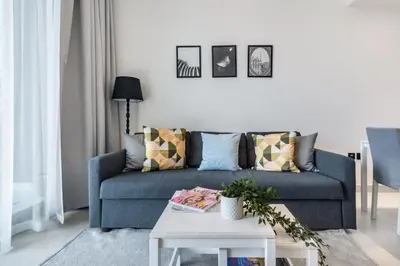 a living room with a blue couch and a table at The Smart Concierge - Binghatti Canal in Dubai