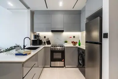 a kitchen with white counters and stainless steel appliances at The Smart Concierge - Binghatti Canal in Dubai