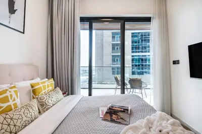 a bedroom with a bed and a balcony at The Smart Concierge - Binghatti Canal in Dubai