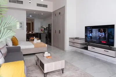a living room with a couch and a tv at Urban Living with Balcony, Pool, and Quick Access to Burj Khalifa in Dubai