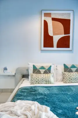 a bedroom with a bed and a picture on the wall at The Smart Concierge - Damac Heights in Dubai